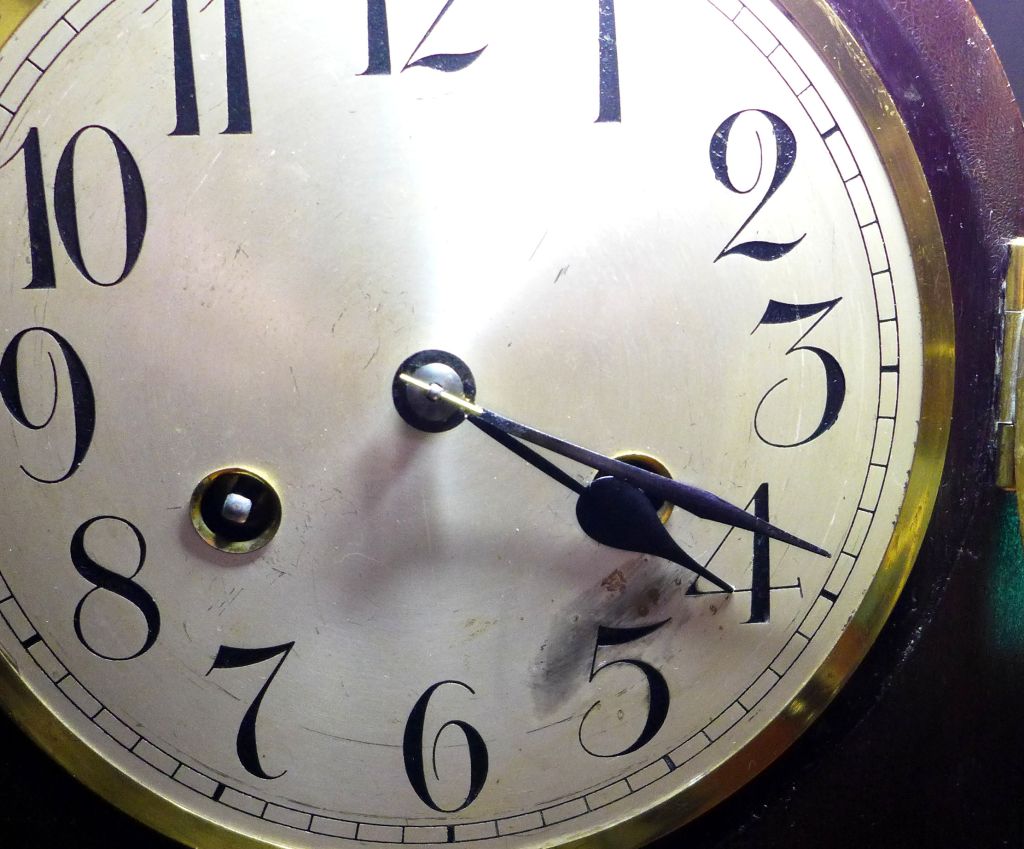 Showing the face of a Junghans mantel clock and the repaired minute hand